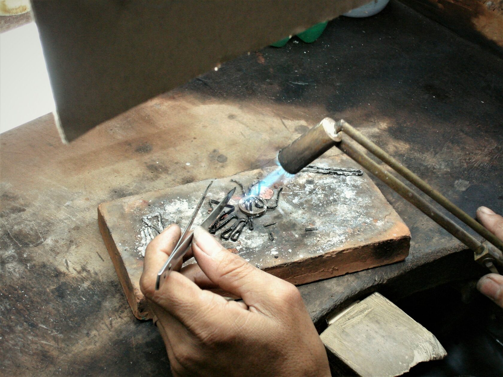 Mãos de artesão a trabalhar filigrana tradicional